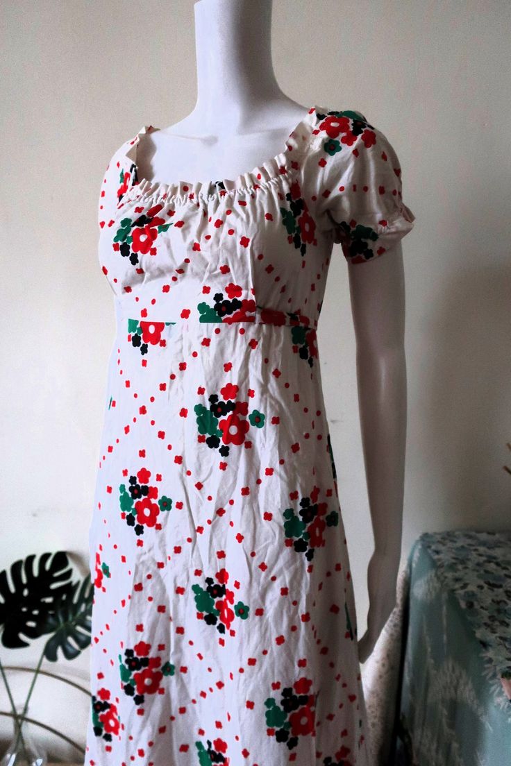 Amazing True Vintage 1970s maxi dress from Finnish designer Heikkilä. Comfortable cotton fabric with nostalgic floral print pattern on white background. Short sleeves, elasticated neckline and cuffs. Fit & flare cut, empire waist. Sewn on tie belt. Zipper in the back, unlined. Made in Finland! BRAND: Heikkilä ERA: 1970s COLOR: White, red, dark blue, green Fabric: No fabric tag, it's cotton SIZE: Vintage size 38, runs smaller and fits best size XS-S, please check the measurements below for refere Square Neck Cotton Maxi Dress With Floral Print, Vintage White Floral Print Maxi Dress, Vintage White Maxi Dress With Floral Print, Retro Cotton Maxi Dress, Retro Floral Print Maxi Dress For Daywear, Blue Green Fabric, Floral Prints Pattern, Red Dark, Maxi Dress Cotton