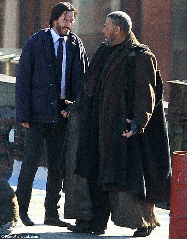 two men standing next to each other on the street