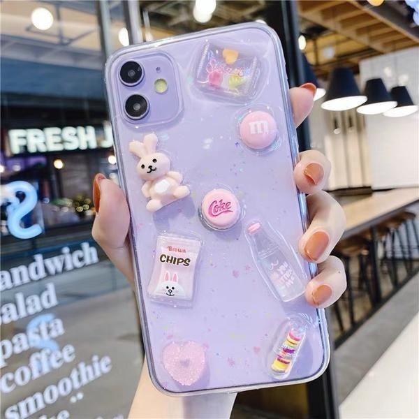 a person holding up a phone case with various stickers on it