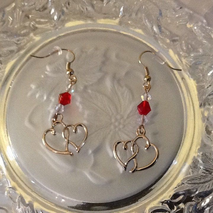 "These Elegant Valentine's Earrings are easily a must for your Sweetheart this year.  Double Hearted Earrings will make you fall in love with them.  The are cute but dainty at the same time. These French Style Ear Wires are Sterling Silver. The Double Hearts are made of Alloy.  Clear and Red Swarovski Bicone Crystals are used to complete the look of Elegance and Beauty.   These special handmade earrings will look good on your Sweetheart, Friend or Daughter or you may want to buy these for yourse Metal Dangle Earrings For Valentine's Day, Handmade Metal Earrings For Valentine's Day, Valentine's Day Handmade Metal Earrings, Earrings With Ear Wire For Valentine's Day Gift, Metal Crystal Earrings For Valentine's Day Gift, Valentine's Day Gift Earrings With Ear Wire, Hypoallergenic Metal Earrings For Valentine's Day, Valentine's Day Hypoallergenic Metal Earrings, Metal Earrings With Ear Wire For Valentine's Day