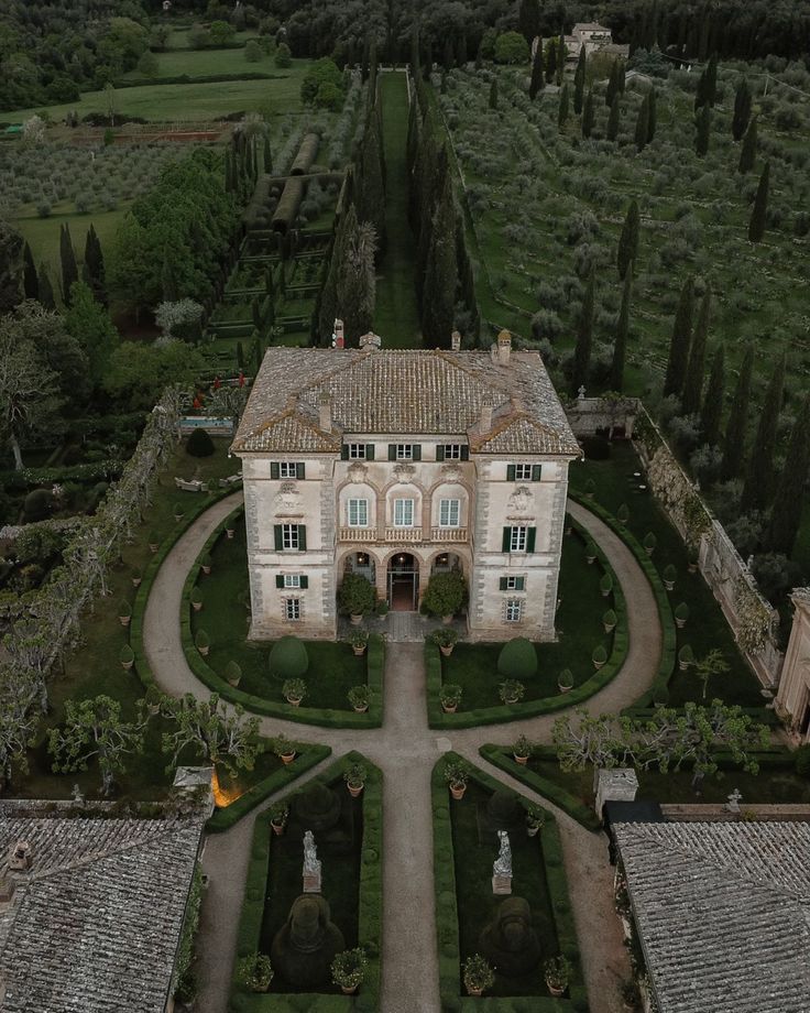 an aerial view of a large house in the middle of a field with lots of trees