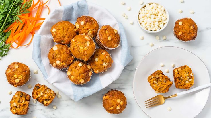 carrot muffins on a plate next to bowls of nuts and other food items