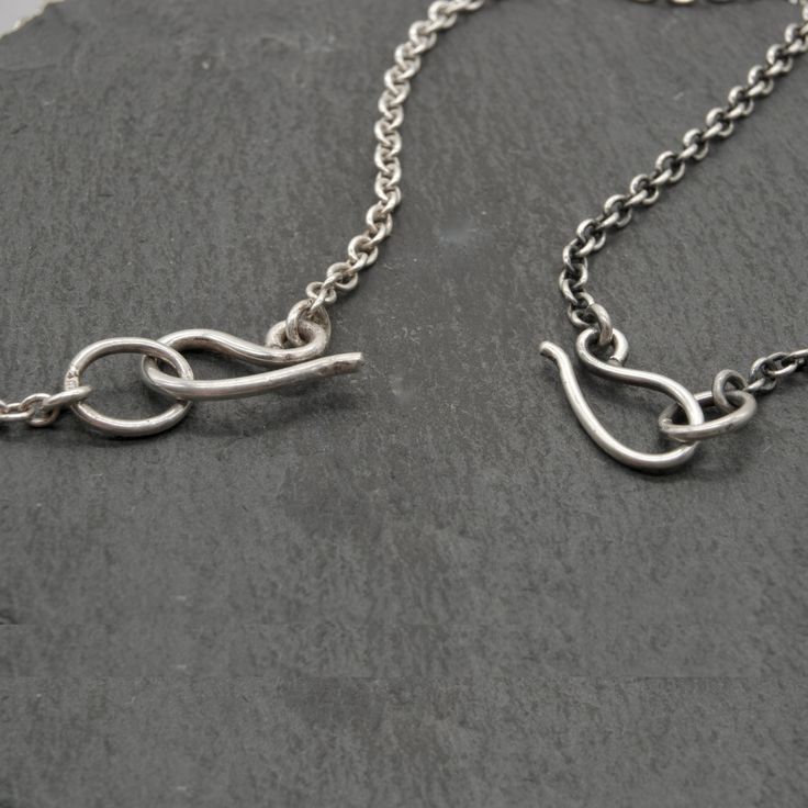 A rolo chain is a staple for mixing and matching charms and pendants. It is a classic and strong chain style, with oval-shaped solid silver links. Choose your preferred length, weight, and finish, and I will cut the chain to any length for you, and add a handmade clasp at the end. I would generally recommend the heavier-weight chain for longer necklaces & larger pendants. If you are purchasing a pendant or charm from me and need help deciding between chain styles, feel free to get in touch so I Sterling Silver Link Chain Charm Necklaces, Silver Toggle Necklace With Adjustable Oval Link Chain, Everyday Rolo Chain Necklace With Oval Links, Silver Oval Link Charm Necklace For Everyday, Sterling Silver Cable Chain Necklace With Oval Links, Silver Charm Necklaces With Adjustable Oval Link Chain, Sterling Silver Oval Pendant Chain Necklace With Adjustable Chain, Minimalist Oval Link Toggle Necklace With Cable Chain, Oval Link Toggle Necklace As Gift