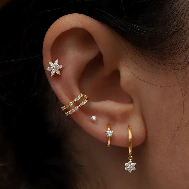 a woman's ear with three different types of piercings