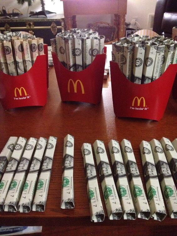 stacks of money sitting in front of mcdonald's buckets on top of a table