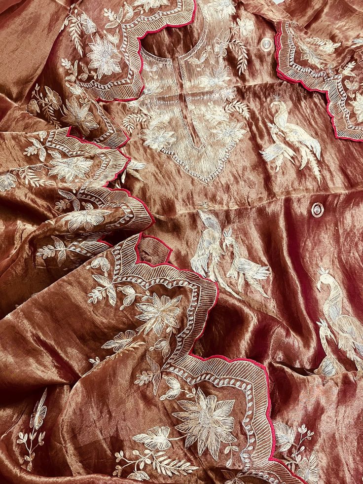 Item Overview ATHARVA Hand Woven Pure Tissue Silk Salwar Kameez/Aari Dori Embroidery/Brownish Gold Tissue/Heirloom Worthy/Custom Stitch Unstitch/Wedding/Plazzo/Gift/ Designer Wear Dno. SK2010 Fabric:  * Shirt: Pure Tissue Silk - Hand Embroidery/ 2.5 Mts Beautiful Aari Dori Work * Dupatta: Pure Tissue Silk - Hand Embroidery/ 2.5 Mts Beautiful Aari Dori Work/Elegant/Tassels/ * Bottom: Pure Tissue Silk 2.5 Mts. Excusive Hand Embroidered Party Wear Punjabi Suit. Customization: * Fabrics Customization: Designs Can be made in different Fabrics. *Color Customization: Designs Can be made in different Colors *Stitching Customization: 1. Salwar Kameez  2. Patiala Salwar Kameez  3. Churridar  4. Tunic Pants  5. Anarkali (Extra Charge) 6. Maxie (Extra Charge) 7. Plazzo Pants 8. Embroidered Pants or Sa Eid Tussar Silk Kurta With Embroidered Border, Tussar Silk Kurta With Embroidered Border For Eid, Semi-stitched Tissue Silk Kurta With Embroidered Border, Transitional Silk Kurta With Embroidered Border, Anarkali Tissue Silk Kurta With Embroidered Border, Bollywood Style Tissue Silk Kurta With Embroidered Border, Traditional Tissue Silk Kurta With Embroidered Border, Traditional Silk Kurta With Embroidered Border, Tussar Silk Traditional Wear With Embroidered Border Straight Kurta