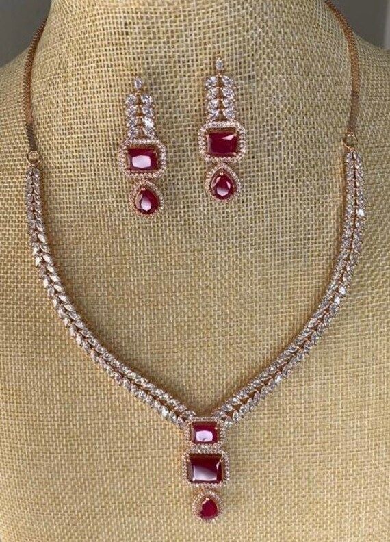 American Diamond with red stone necklace and earrings set. Elegant Red Jewelry Sets For Festive Occasions, Elegant Red Festive Jewelry, Festive Red Necklaces With Matching Earrings, Festive Red Necklace With Matching Earrings, Festive Red Ruby Jewelry Set, Elegant Red Jewelry With Stone Setting, Red Ruby Jewelry Sets With Matching Earrings, Elegant Red Necklace For Festive Occasions, Red Costume Jewelry Sets For Formal Occasions