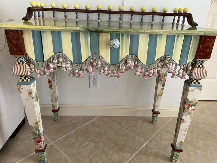 an elaborately decorated table in the corner of a room with tile flooring and white walls