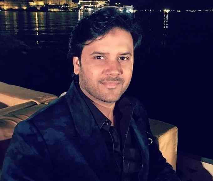 a man sitting in a boat at night with his arms crossed and looking into the camera