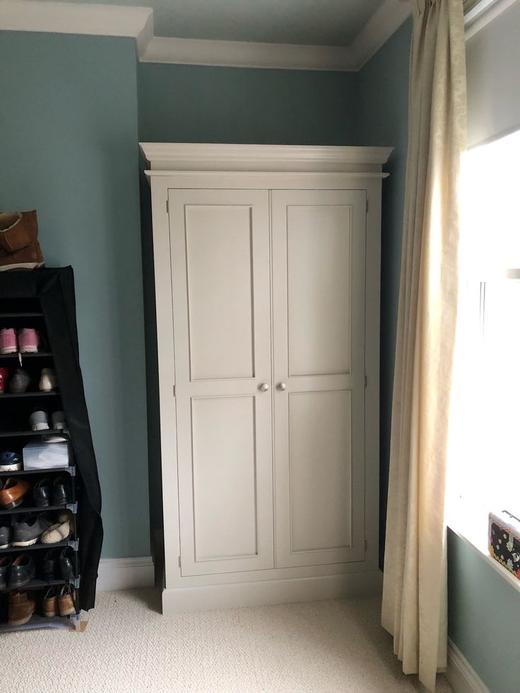 there is a closet in the corner of this room with shoes on it and an open window