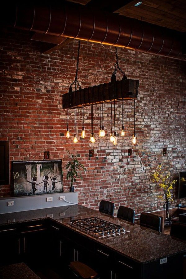 a brick wall with lights hanging from it's ceiling and chairs around the table