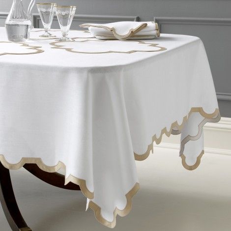 a white table cloth with gold trim on it