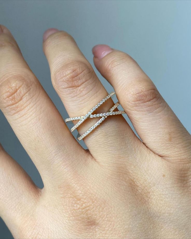 a woman's hand with a diamond ring on top of her left hand,