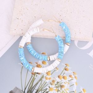 two blue and white beaded necklaces sitting on top of a table next to flowers