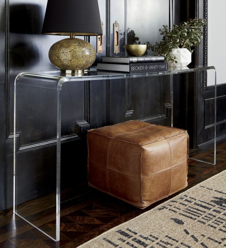 a living room with a brown leather ottoman