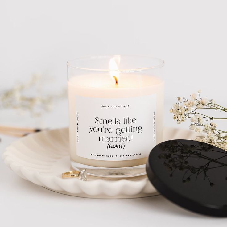 a white candle sitting on top of a plate next to a black heart shaped object