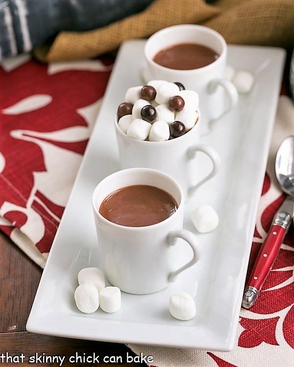 two mugs of hot chocolate with marshmallows on a white serving tray