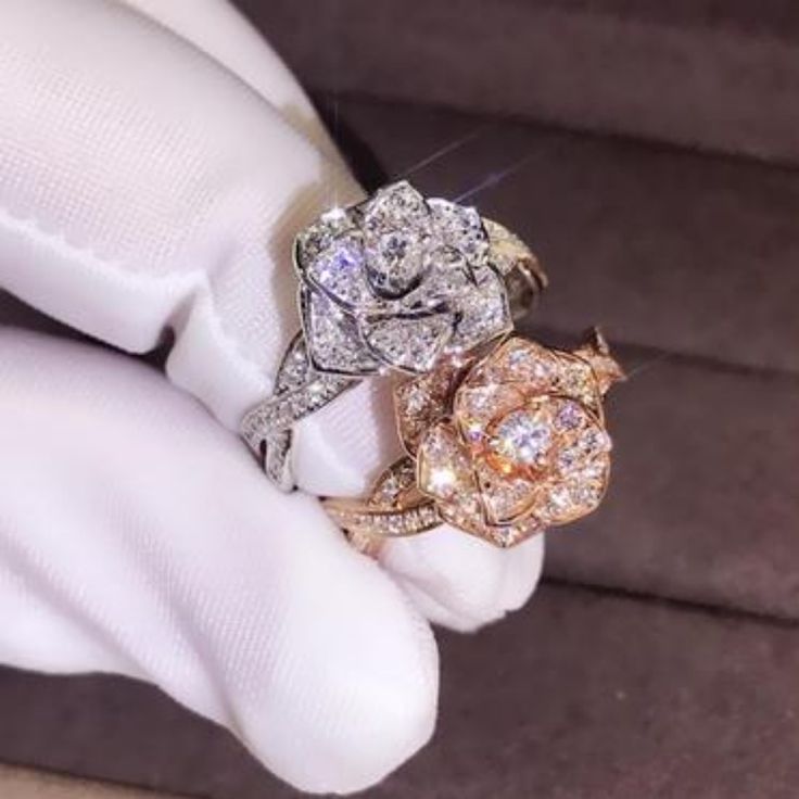 a close up of a person's hand with three rings on their fingers and two diamonds in the middle