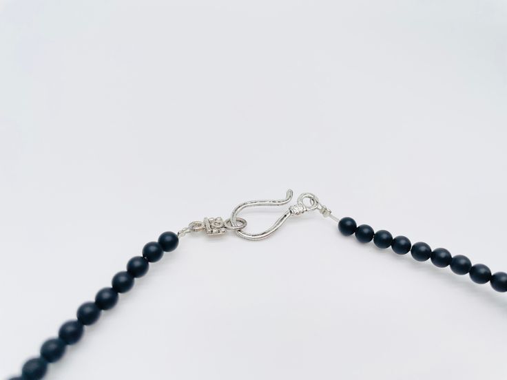 Discover the epitome of masculine elegance with our handmade Men's Gemstone Necklace. Meticulously crafted using a blend of Black Silk Stone chip beads and Matte Black Onyx gemstones, this necklace exudes a sense of strength and sophistication. Elevate your style with the dark allure of these genuine gemstones, carefully chosen to create a piece that complements any look. The necklace is 18 inches long with the option to add a chain extender. Features a pewter fish hook clasp for easy of use. Minimalist Onyx Round Bead Jewelry, Minimalist Onyx Bead Jewelry, Minimalist Beaded Onyx Jewelry, Minimalist Onyx Beaded Jewelry, Single Strand Onyx Jewelry Gift, Gift Onyx Single Strand Jewelry, Adjustable Onyx Gemstone Beads Crystal Necklace, Adjustable Onyx Crystal Necklace With Gemstone Beads, Masculine Elegance