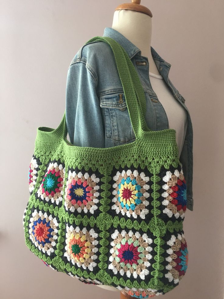 a green crocheted bag on a mannequin head with a denim jacket