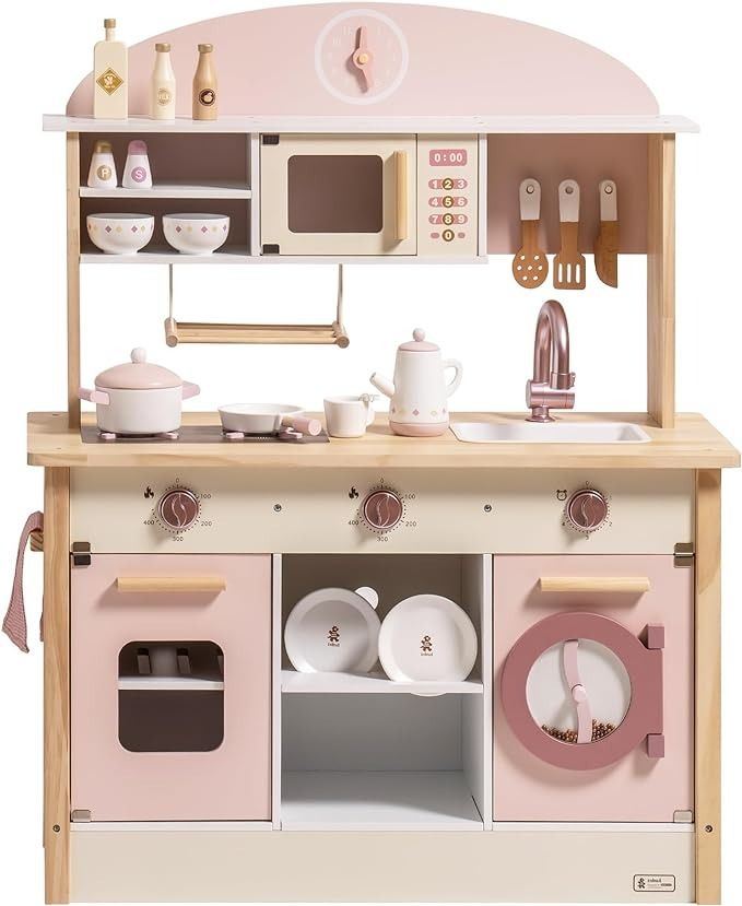 a wooden toy kitchen with pink appliances and dishes on the counter, including an oven