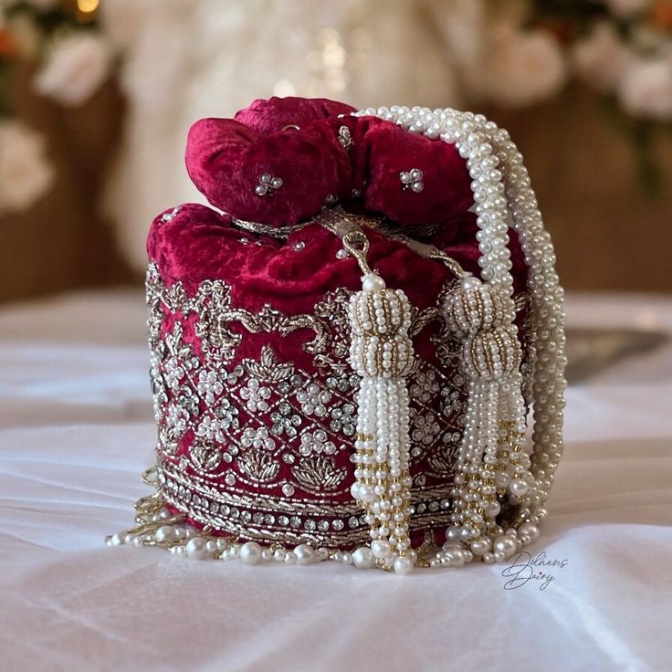 Indulge in timeless elegance with our exquisite bridal potli bag, meticulously crafted in deep red velvet to capture the essence of luxury and tradition. Designed with South Indian brides in mind, this opulent accessory is adorned with intricate dabka, beadwork, sparkling stones, and shimmering sequins, ensuring a mesmerizing entrance on your special day. Elevate your bridal ensemble with this stunning potli bag, a symbol of sophistication and grace. Product Details: *Handmade with traditional Pakistani and Indian techniques *Spacious interior  *Measures 6 inches To explore additional styles, kindly visit our website at dulhansdiary.etsy.com. . . . . . . #silverpotlibag #handmadeclutch #bridalhandbag #weddingaccessories #ethnicbag #uniquegift #artisanmadeclutch #punjabiclutches #potlibag # Hand Bag For Bride, Bridal Bag For Wedding Day Indian, Bride Purse Wedding Day, Elegant Red Embroidered Shoulder Bag, Luxury Red Formal Pouch, Red Pouch Clutch For Festivals, Red Embroidered Pouch Clutch, Traditional Red Party Bag, Embroidered Red Pouch Clutch