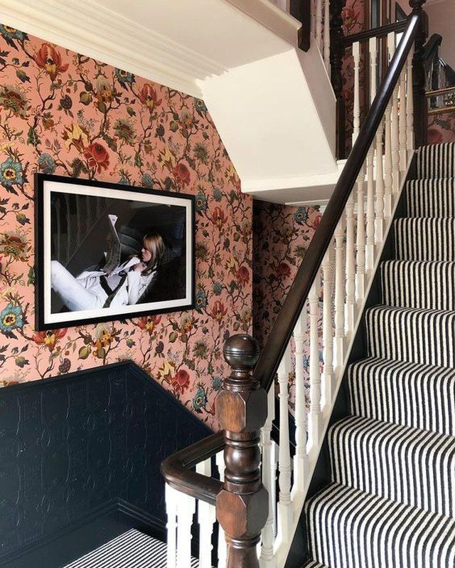 the stairs are decorated with black and white striped wallpaper, along with a framed photograph on the wall