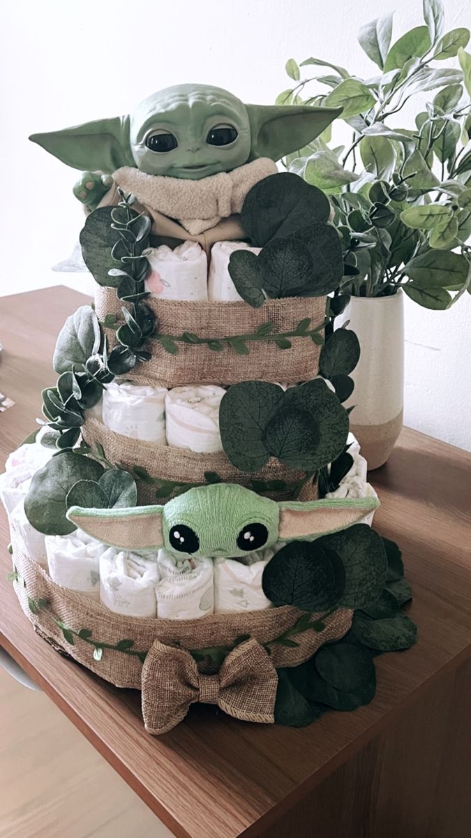 a stack of baby yoda diapers sitting on top of a wooden table next to a potted plant