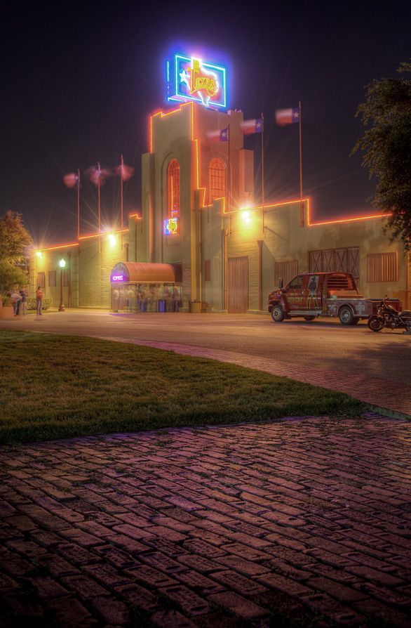 an old building lit up at night with neon lights