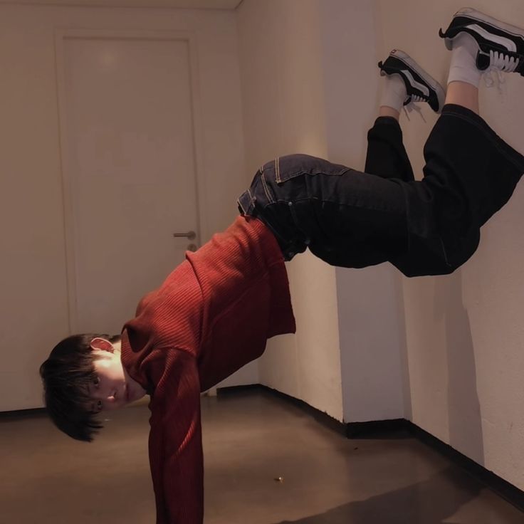 a young boy is doing a handstand on the floor