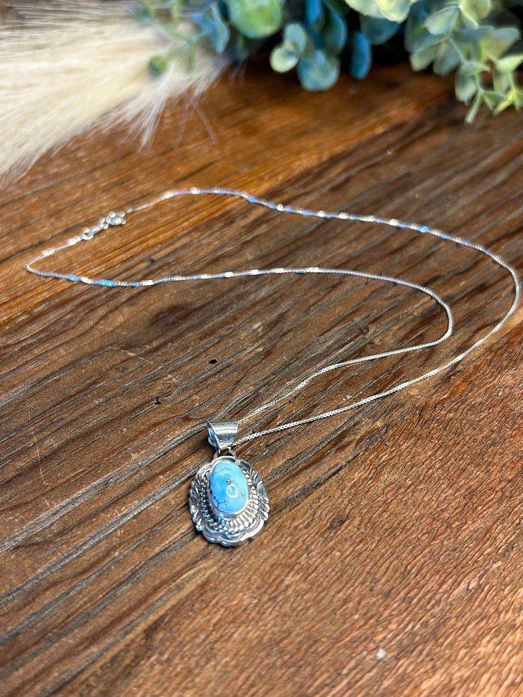 This simple yet beautiful Golden Hills Turquoise Necklace is made by Navajo Silversmith Artist V Chee.  The sky blue Golden Hills Turquoise teardrop stone is set in a smooth sterling silver bezel and surrounded with twisted rope and hand stamped design. Pendant sits on a 18" 925 sterling silver stamped chain with a spring ring clasp.   Golden Hills Turquoise is mined in the Altai Mountains in Kazakhstan.  It is believed to promote positive energy, emotional balance, and overall well-being making Southwestern Sterling Silver Necklaces With Round Pendant, Southwestern Sterling Silver Necklace With Round Pendant, Southwestern Silver Necklace With Oval Pendant, Southwestern Sterling Silver Oval Pendant Necklace, Southwestern Silver Gemstone Necklaces, Southwestern Silver Necklaces With Gemstones, Southwestern Style Silver Gemstone Necklaces, Silver Southwestern Necklace With Gemstone, Silver Southwestern Style Gemstone Necklace