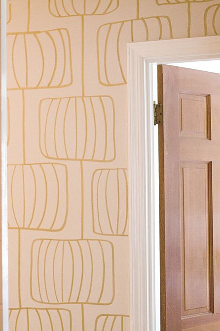 an open door in front of a wallpapered room with gold circles on it