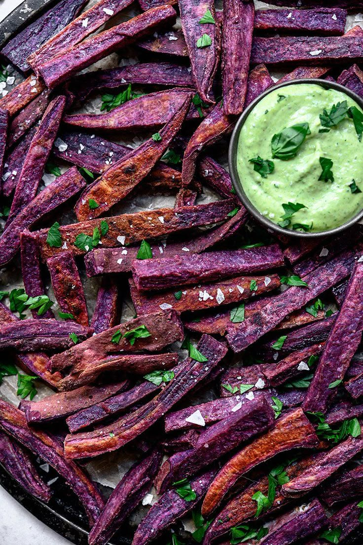 baked sweet potato wedges with guacamole dip on top, ready to be eaten