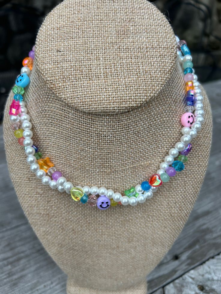 Y2K Beaded Pearl Necklace  This funky and flirty layered pearl necklace is the perfect gift for anyone. Made with beautiful lustrous 6mm white glass pearls and a mix of colorful acrylic heart, star, crystal, smiley faces, and round beads. Pearls and beads are strung on sturdy, stretchy jewelry beading cord with a 2" adjustable stainless steel lobster claw closure. Necklace shown is 14", but other lengths are available. All items can be customized, please message me with your requests. ChooseLove White Necklaces With Colorful Beads For Party, Trendy White Beaded Necklaces For Party, Multicolor Pearl Beaded Necklaces For Parties, Trendy White Pearl Necklace For Party, Whimsical White Pearl Jewelry, White Beaded Necklace With Pearl Charm For Party, Trendy White Pearl Chain Beaded Necklaces, Party Beaded Necklaces With Letter And Round Beads, White Double Strand Pearl Necklace For Party