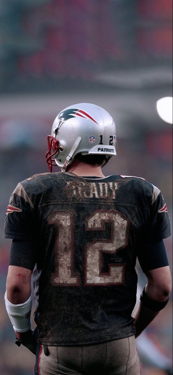 a football player with a helmet on standing in front of an empty bleachers