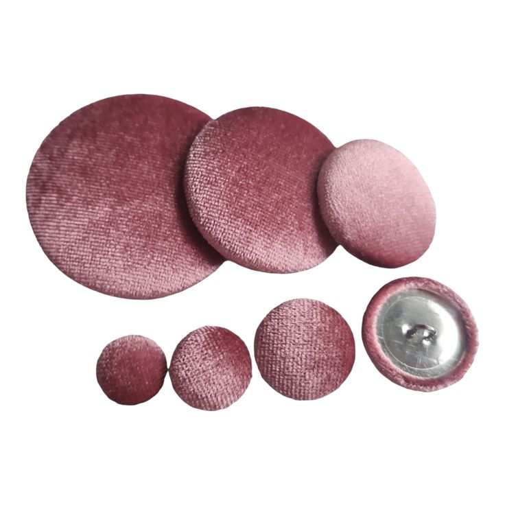 three pink buttons and one silver button are shown in this image on a white background