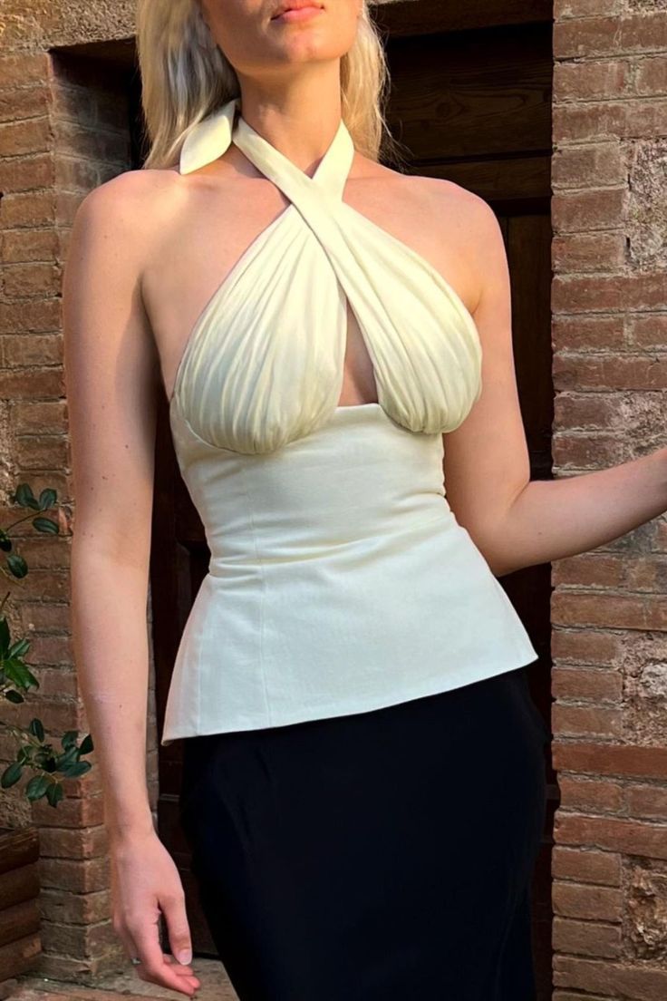 Inspired by a vintage halter top one's mother wore in her 30's, took us on a journey to create our own take on one's youthful memories in this statement piece. Chic Beige Halter Neck Top, Chic White Fitted Halter Top, Elegant White Halter Top For Date Night, Boned Bodice Tops For Summer Evenings, Chic Cream Halter Top For Summer, White Fitted Feminine Halter Top, White Fitted Halter Top For Evening, Fitted Sleeveless Halter Top For Wedding, White Boned Bodice Top For Evening