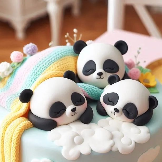 there are three panda bears that are on top of the cake together and one is sleeping