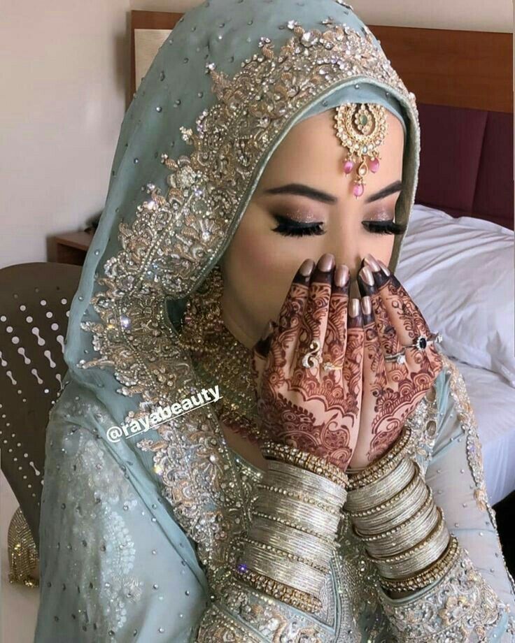 a woman wearing a veil and holding her hands to her face