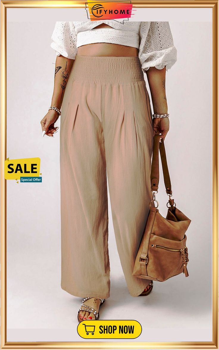 a woman in wide legged pants holding a handbag