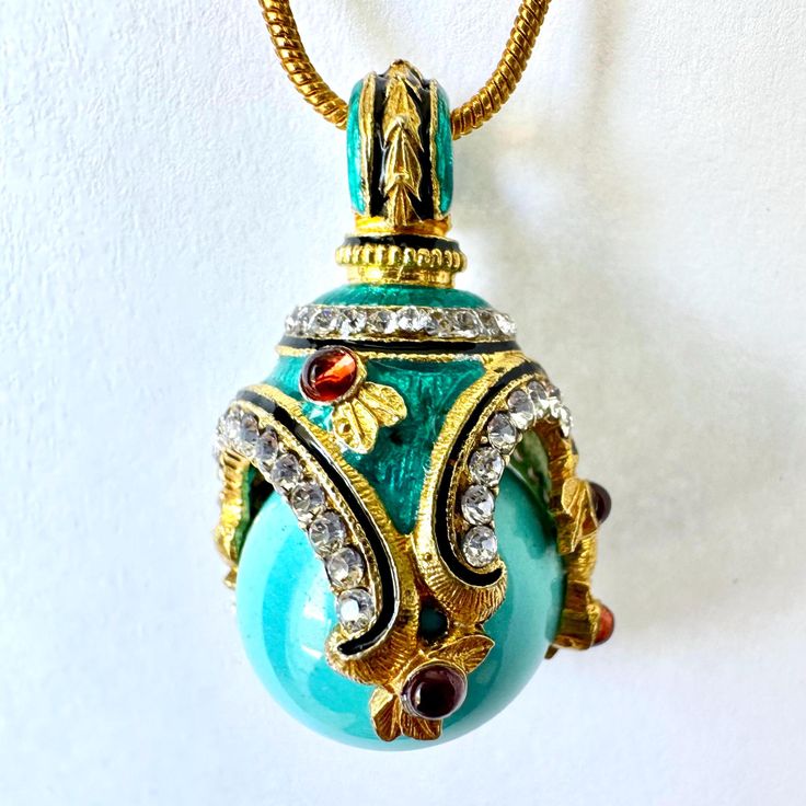 This high-quality, handmade, magnificent pendant was inspired by and designed in a Faberge style. The  14mm turquoise ball is set in a 24k gold plated 925 sterling silver asymmetric circle design with curvy chains of 1.5mm clear and shining Premium crystals. Black narrow lines divide transparent Guilloché blue enamel and crystals. The 6 by 2mm genuine cabochon garnets add a beautiful accent and strong contrast to the necklace. Bail, on the top of the item, also with matching enamel, and surrounded by the chain of crystals. The pendant is 1.25" in height and with a 24-inch gold plated snake chain comes with a jewelry box. I am a professional jewelry designer, who graduated from Saint Petersburg's Art and Design Academy. Immigrating to the USA, I brought back Faberge's style and traditional Enamel Necklace With Detachable Pendant, Gold Enamel Necklace With Cabochon, Gold Enamel Necklaces With Cabochon, Unique Collectible Jeweled Jewelry, Traditional Teardrop Pendant Jewelry Gift, Jeweled Pendant Jewelry Gift, Ornate Jeweled Pendant Jewelry, Jeweled Pendant Necklaces For Gifts, Unique Jeweled Jewelry As Gift