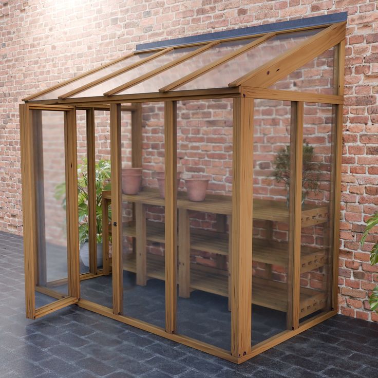 a wooden greenhouse in front of a brick wall with potted plants on the shelves