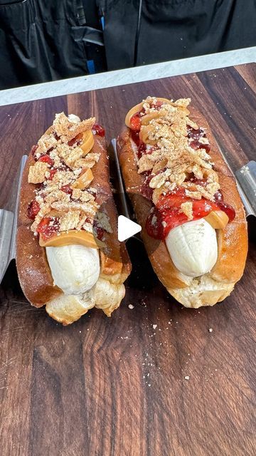 two hot dogs on buns with toppings and a knife