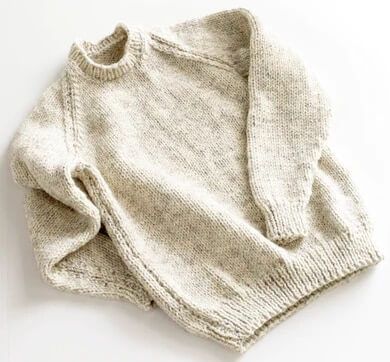 two sweaters sitting next to each other on a white surface