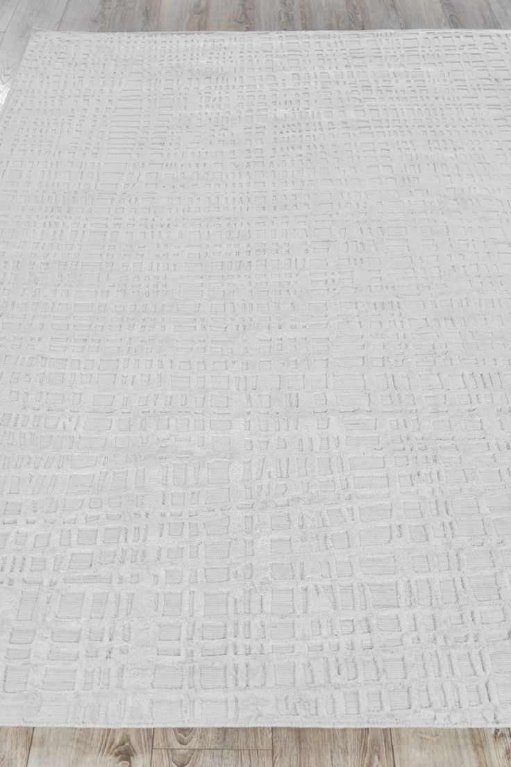 a large white rug on top of a wooden floor