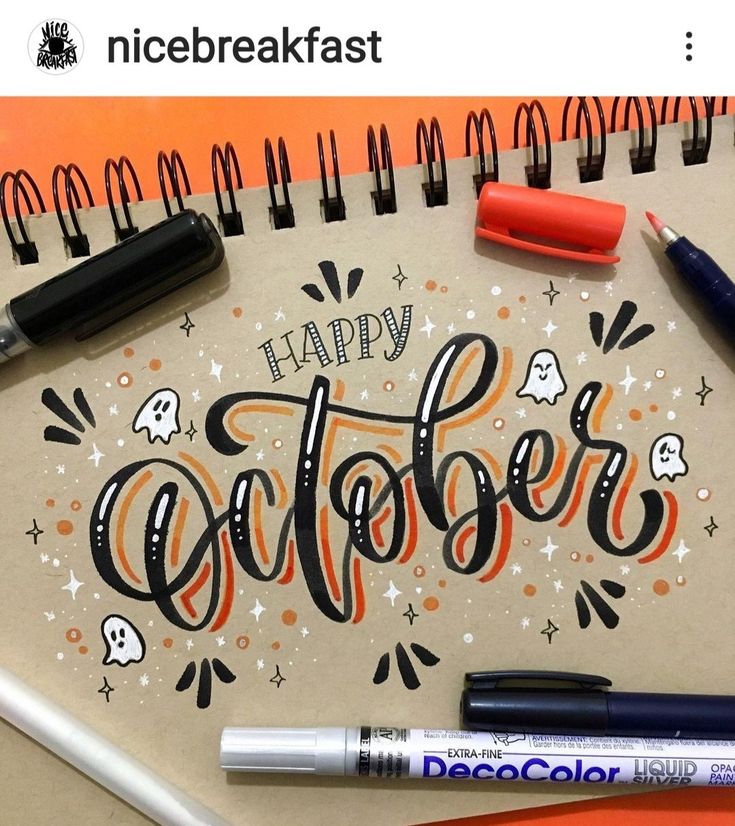 a notepad with the words happy october written on it next to markers and pens