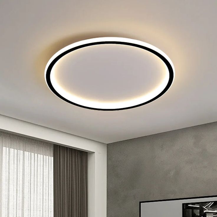 a modern ceiling light with dim lighting in a living room or dining room, above a bed