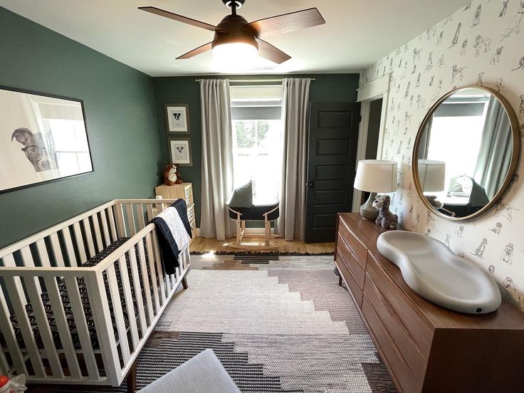 a baby's room with a crib, dresser and mirror