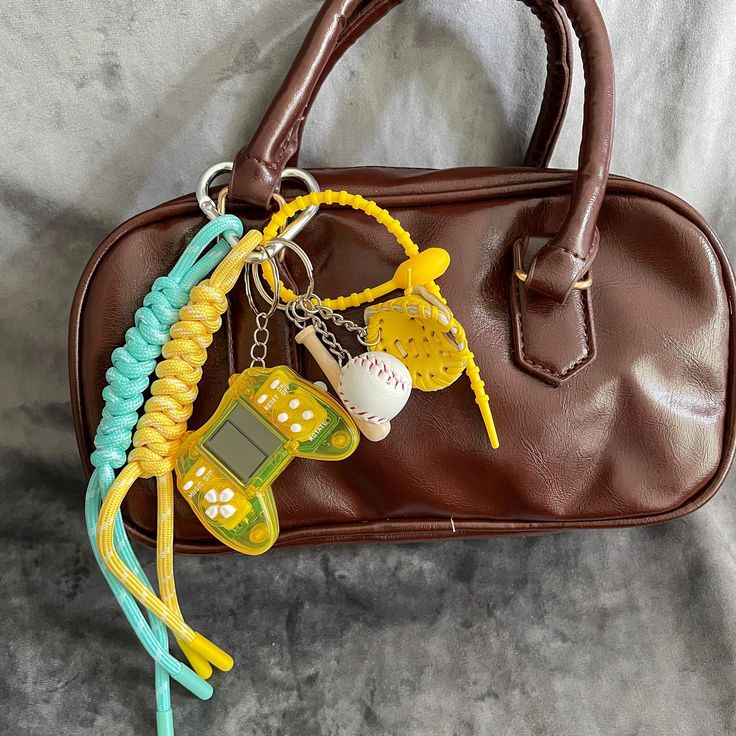 a brown purse with some keys attached to it and a cell phone keychain