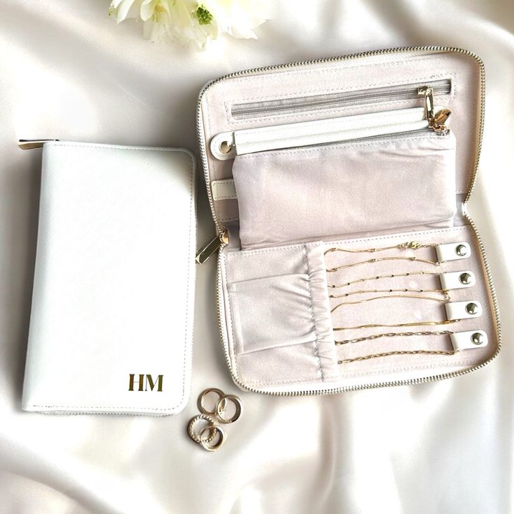 an open white purse sitting on top of a bed next to two pairs of scissors